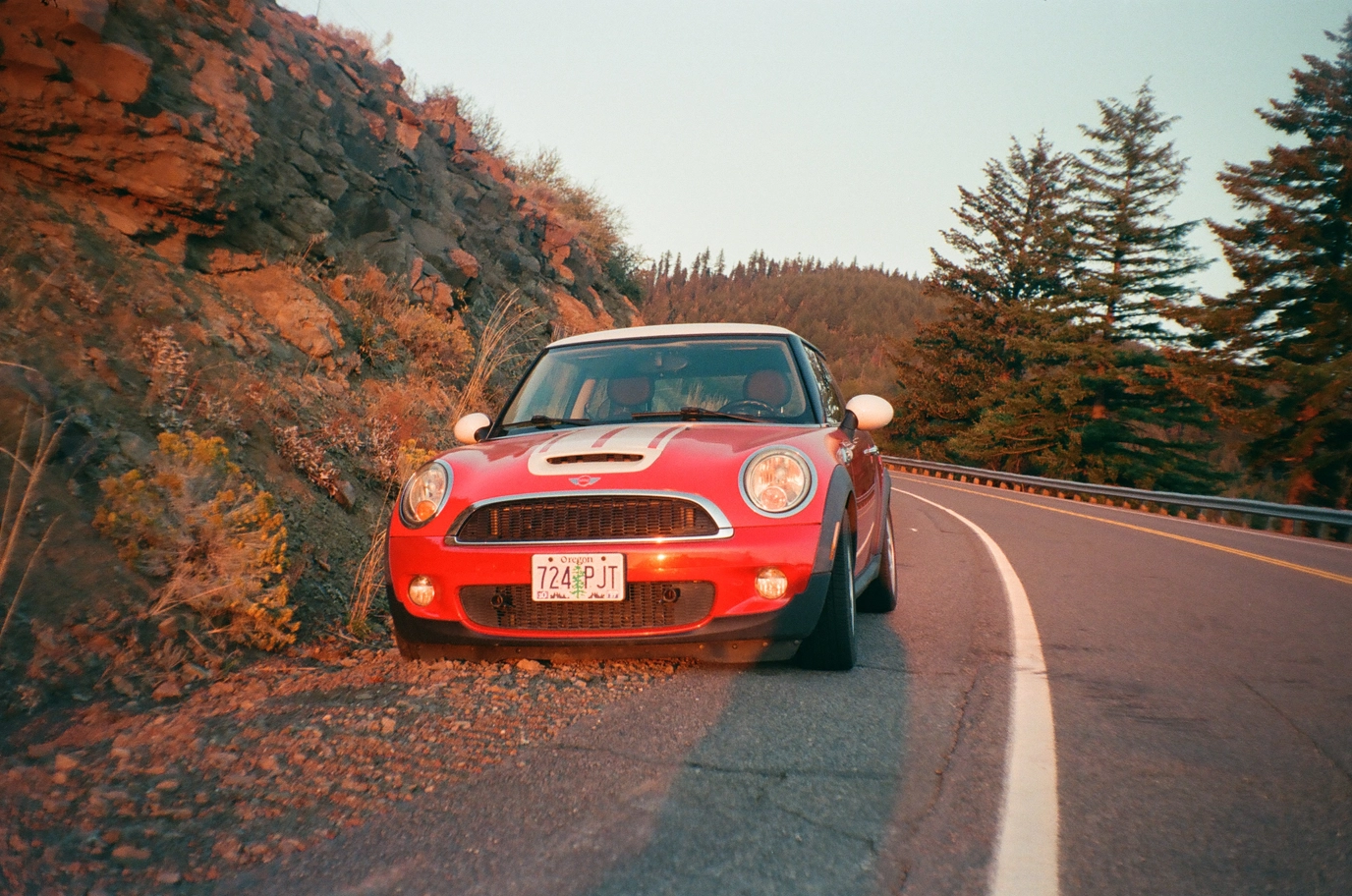 A photo of a red mini cooper during sunset
