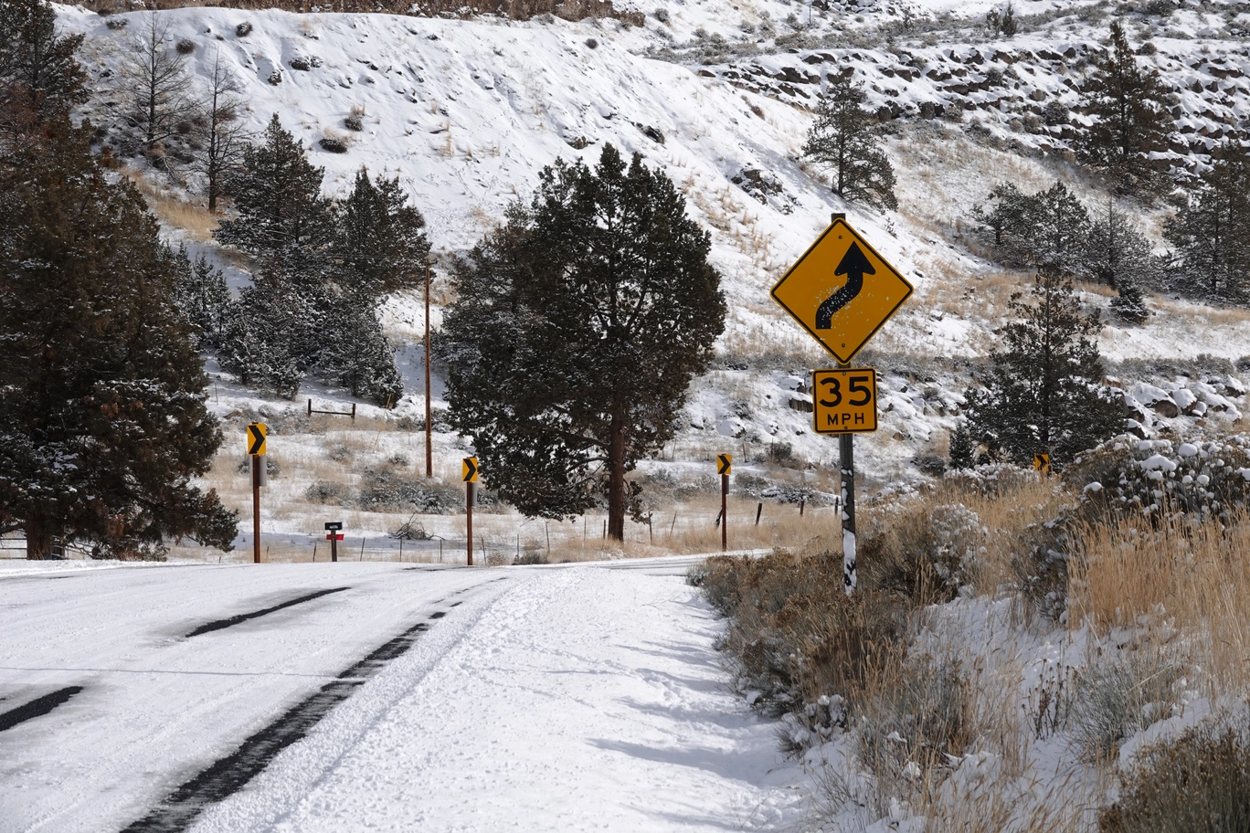A photo of a snowy road and mountains