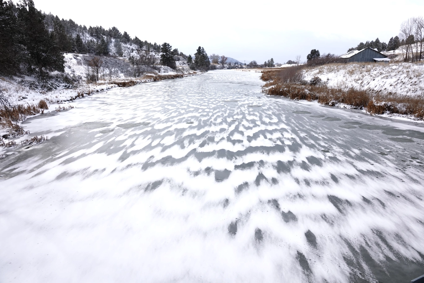A photo of a frozen, snowy river