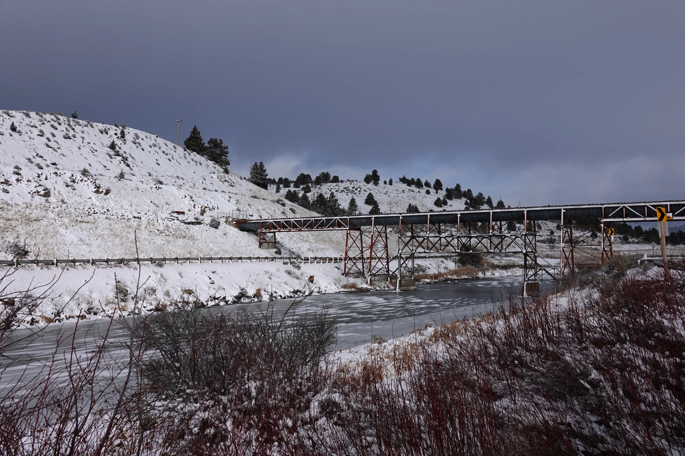A photo of an aqueduct(?) bridging across a frozen, snowy river