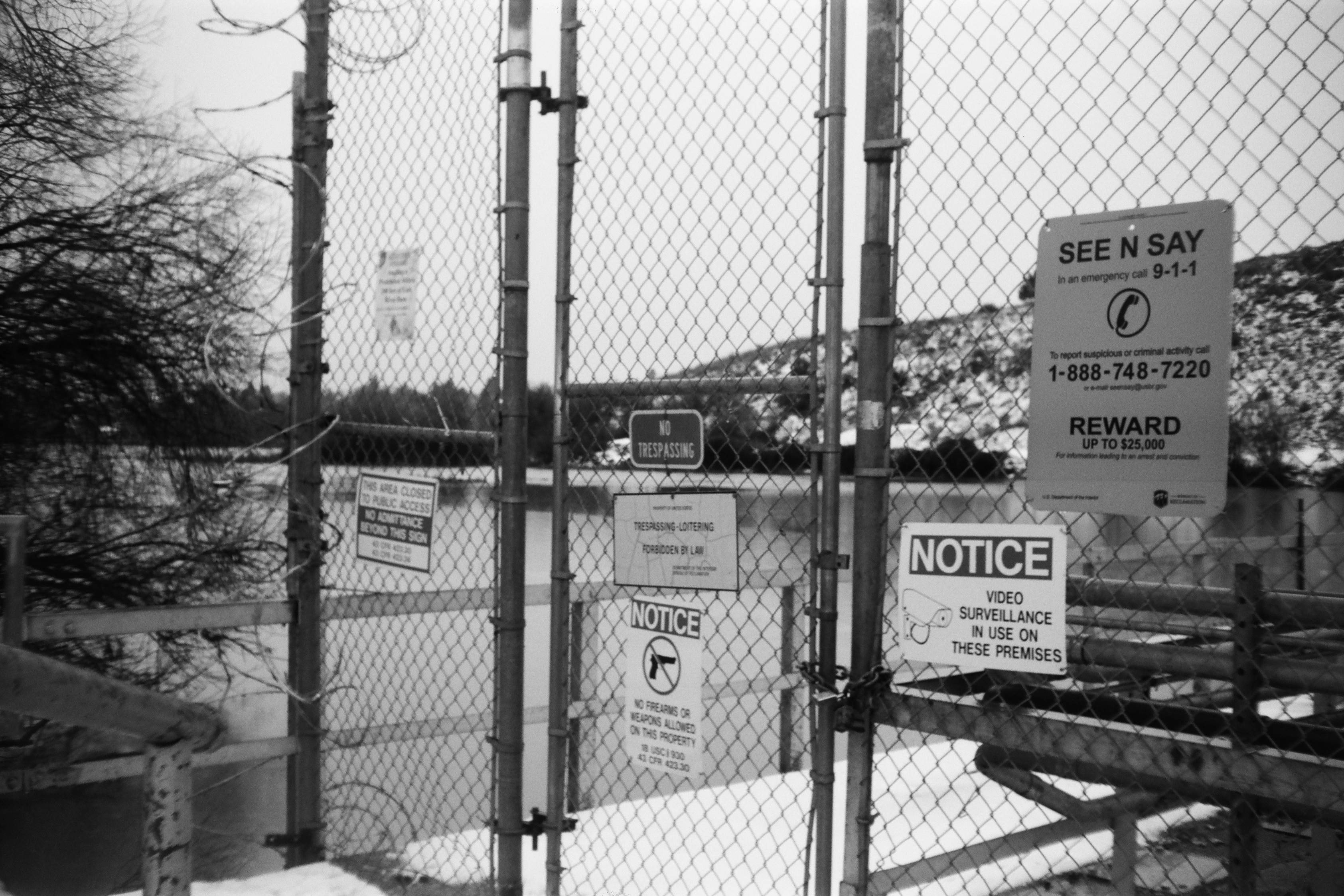 A photo of a fence with many warning signs