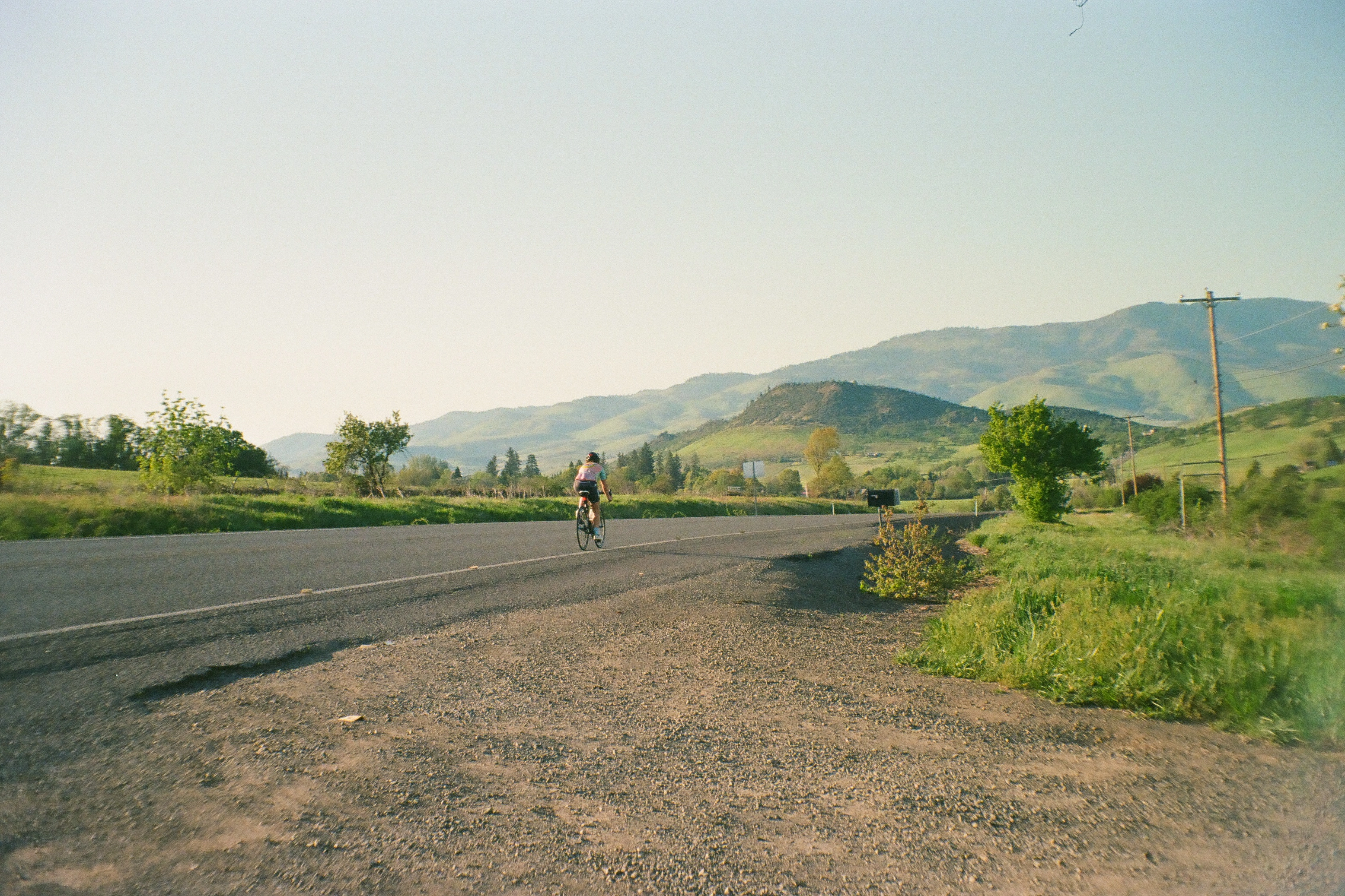 A photo of person cycling down a road