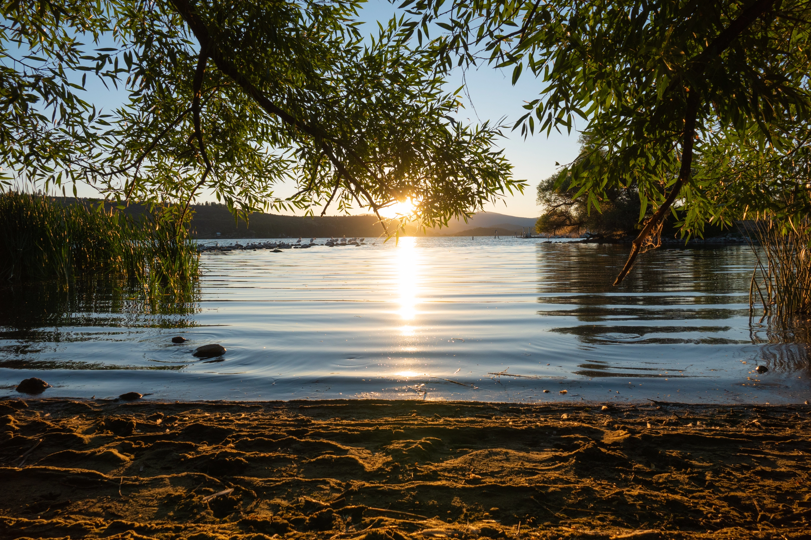 A photo of the sun setting over a lake