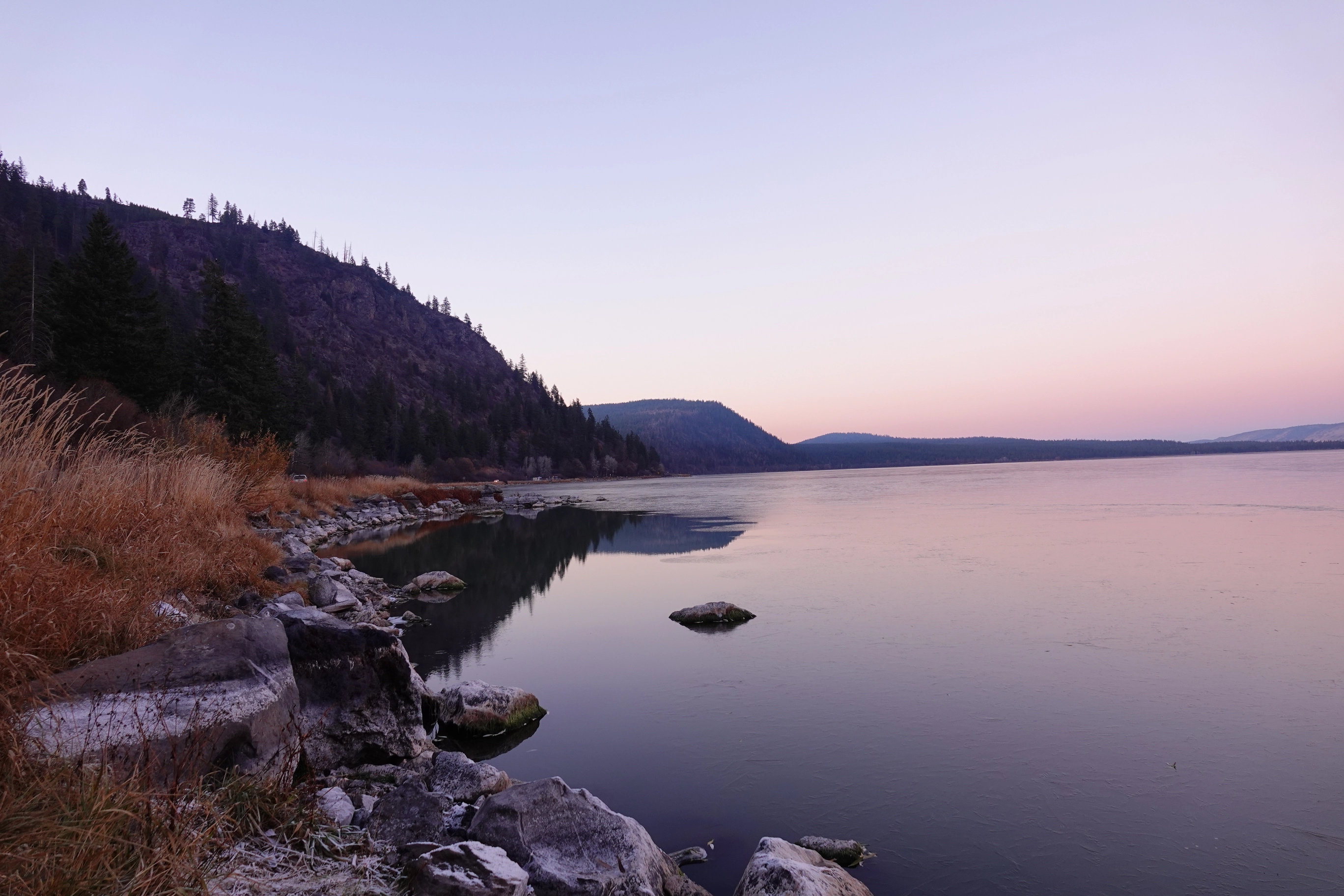A photo of a lake shore during sunset