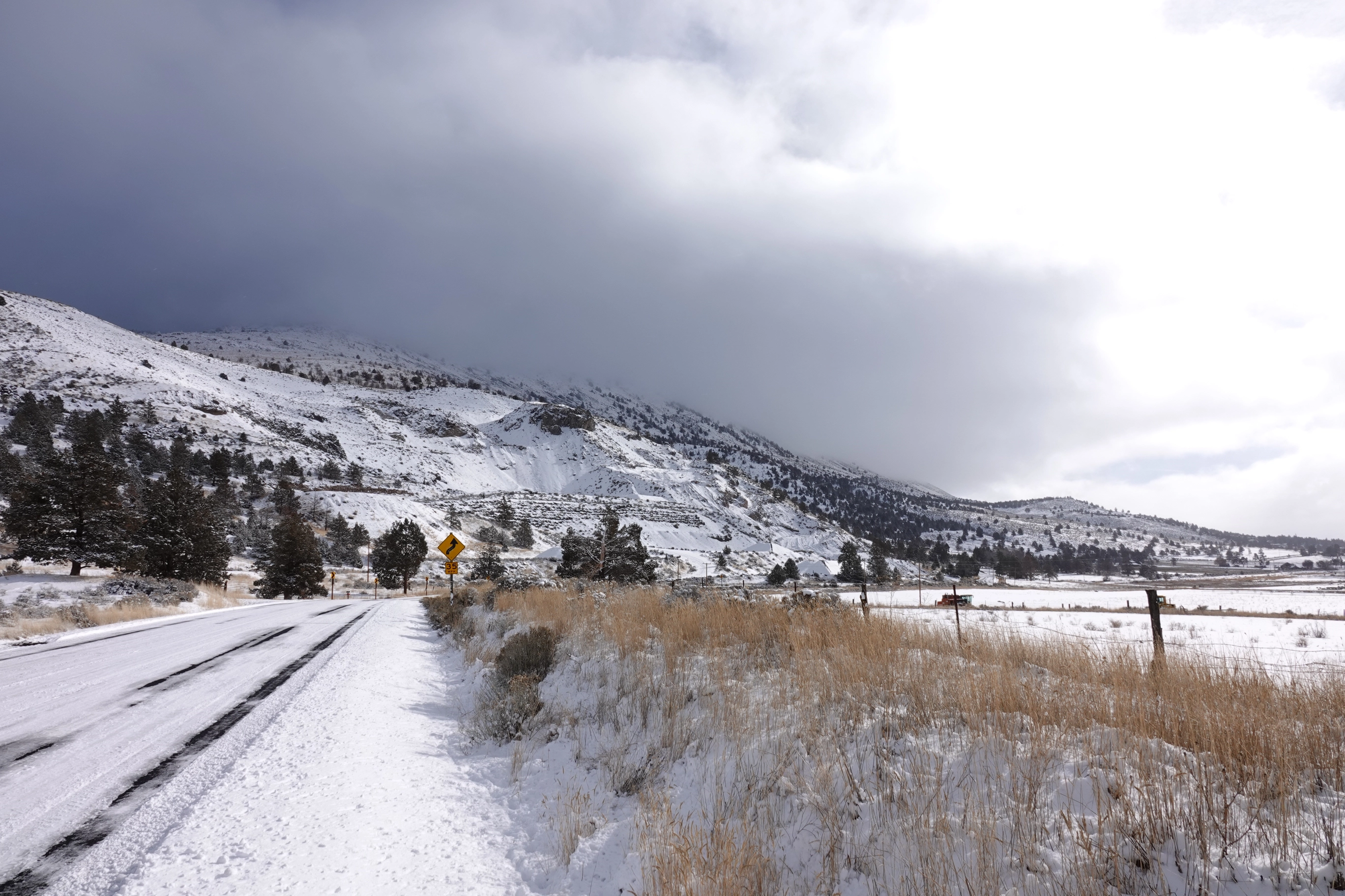A photo of a snowy road and mountains