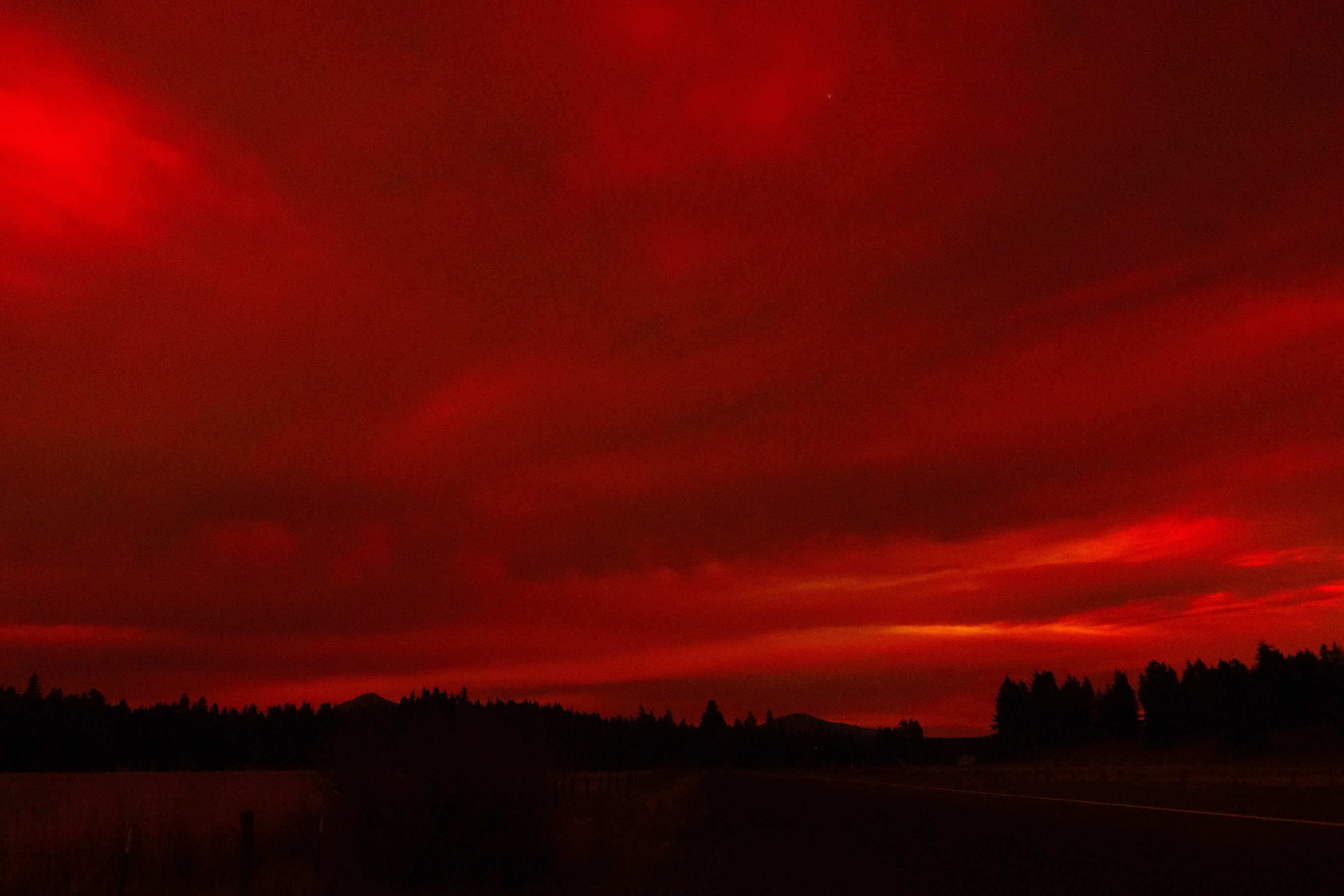 A photos of red clouds covering the sky at night due to the Aurora Borealis